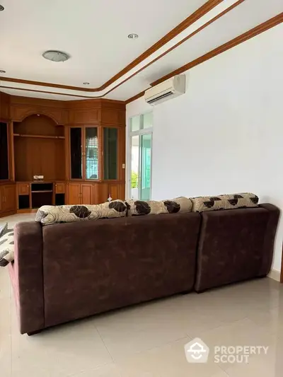 Spacious living room with elegant wooden cabinetry and plush sofa