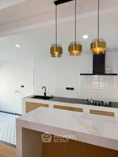 Modern kitchen with marble island and stylish pendant lights