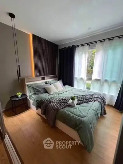 Modern bedroom with stylish decor and large window offering natural light.