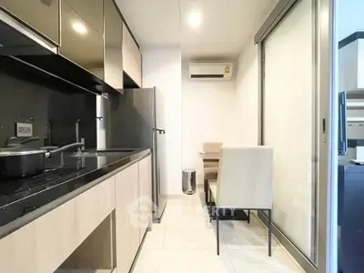 Modern kitchen with sleek cabinets and dining area in compact space