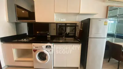 Modern kitchen with sleek appliances including washing machine and fridge, ideal for urban living.