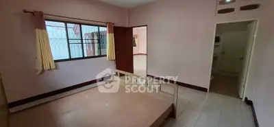 Spacious bedroom with large window and minimalist wooden bed frame