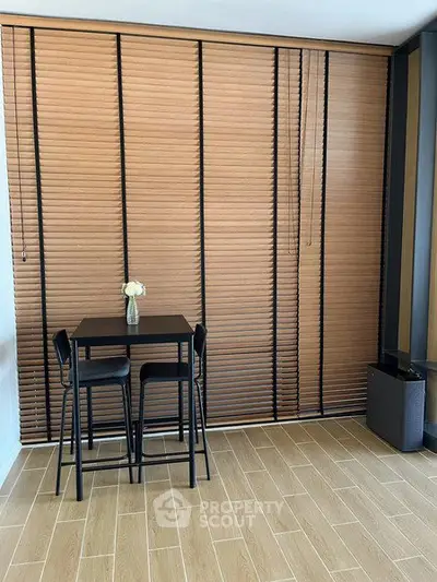 Modern dining nook with wooden blinds and sleek furniture in a stylish apartment.