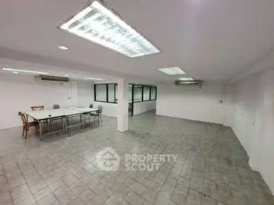 Spacious office space with tiled flooring and fluorescent lighting, ideal for business setup.