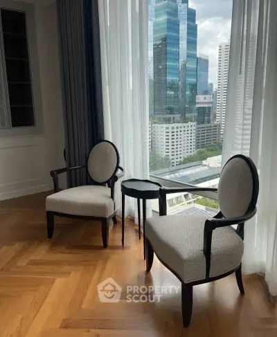Elegant corner unit with city view, featuring stylish chairs and hardwood flooring, perfect for urban living.