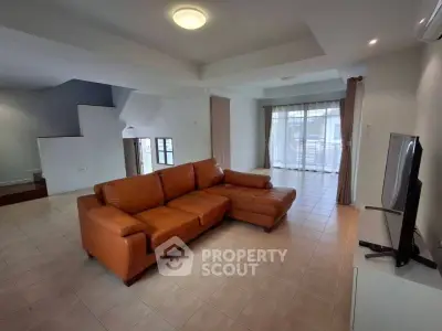 Spacious living room with modern leather sofa and large windows for natural light.