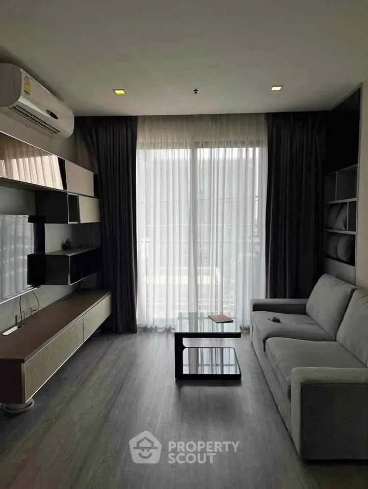 Modern living room with sleek furniture and large window for natural light.
