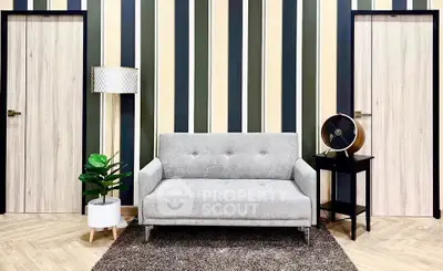 Modern living room with stylish sofa, striped wall, and chic decor
