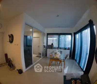 Spacious modern living room with large windows and dining area, perfect for family gatherings.