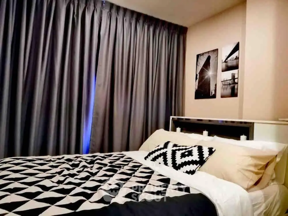 Cozy bedroom with stylish decor and modern art, featuring a comfortable bed and elegant curtains.