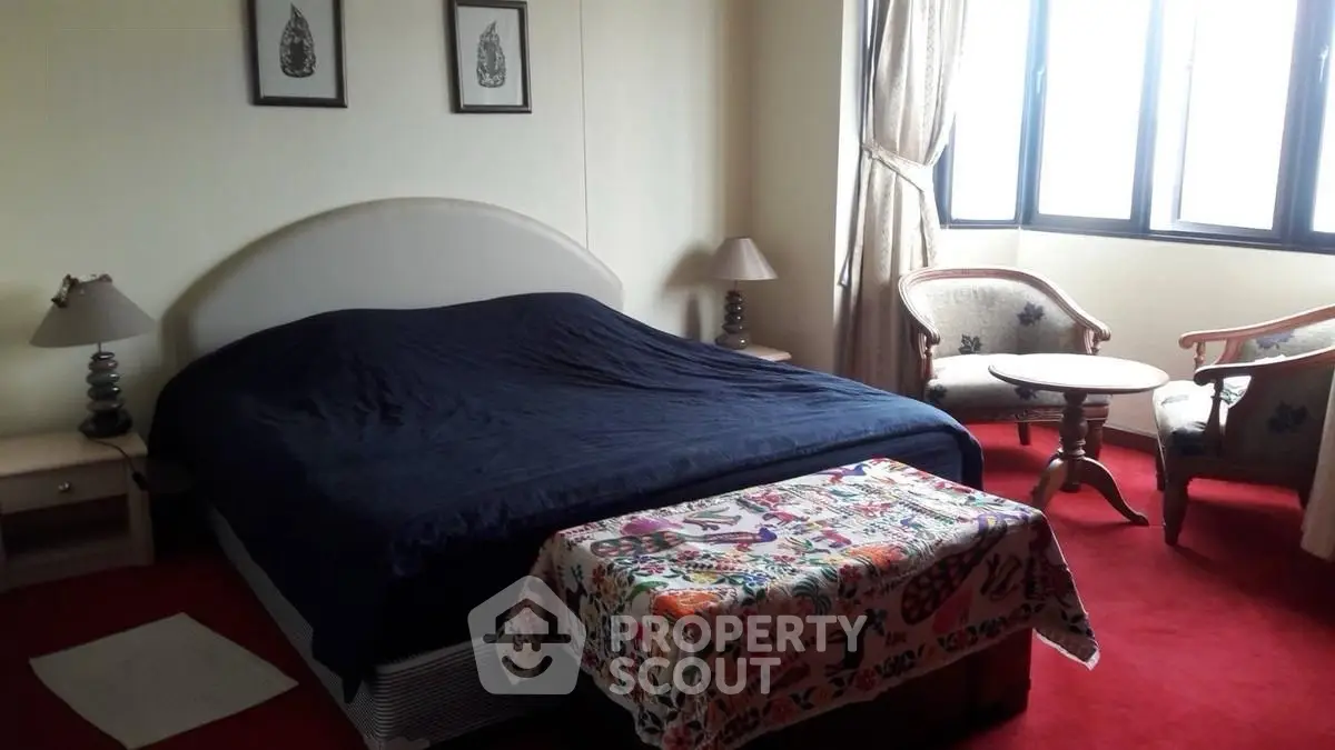 Cozy bedroom with elegant decor and natural light, featuring a comfortable bed and stylish seating area.