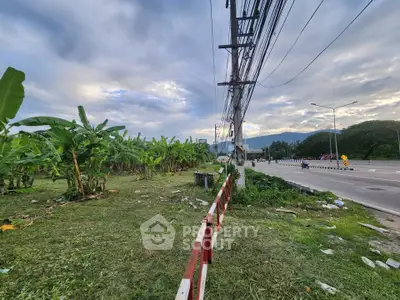 Scenic land plot with lush greenery and mountain views, ideal for development.