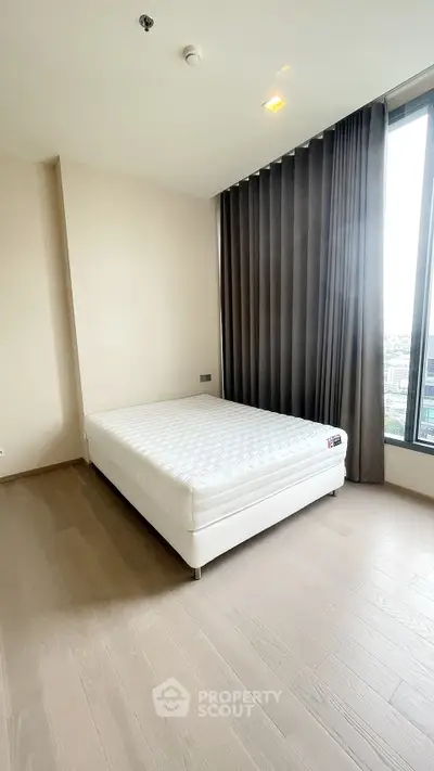 Spacious bedroom with large window and modern minimalist design