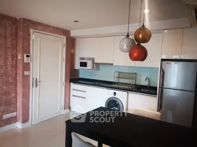 Modern kitchen with sleek appliances and stylish lighting in a contemporary apartment.