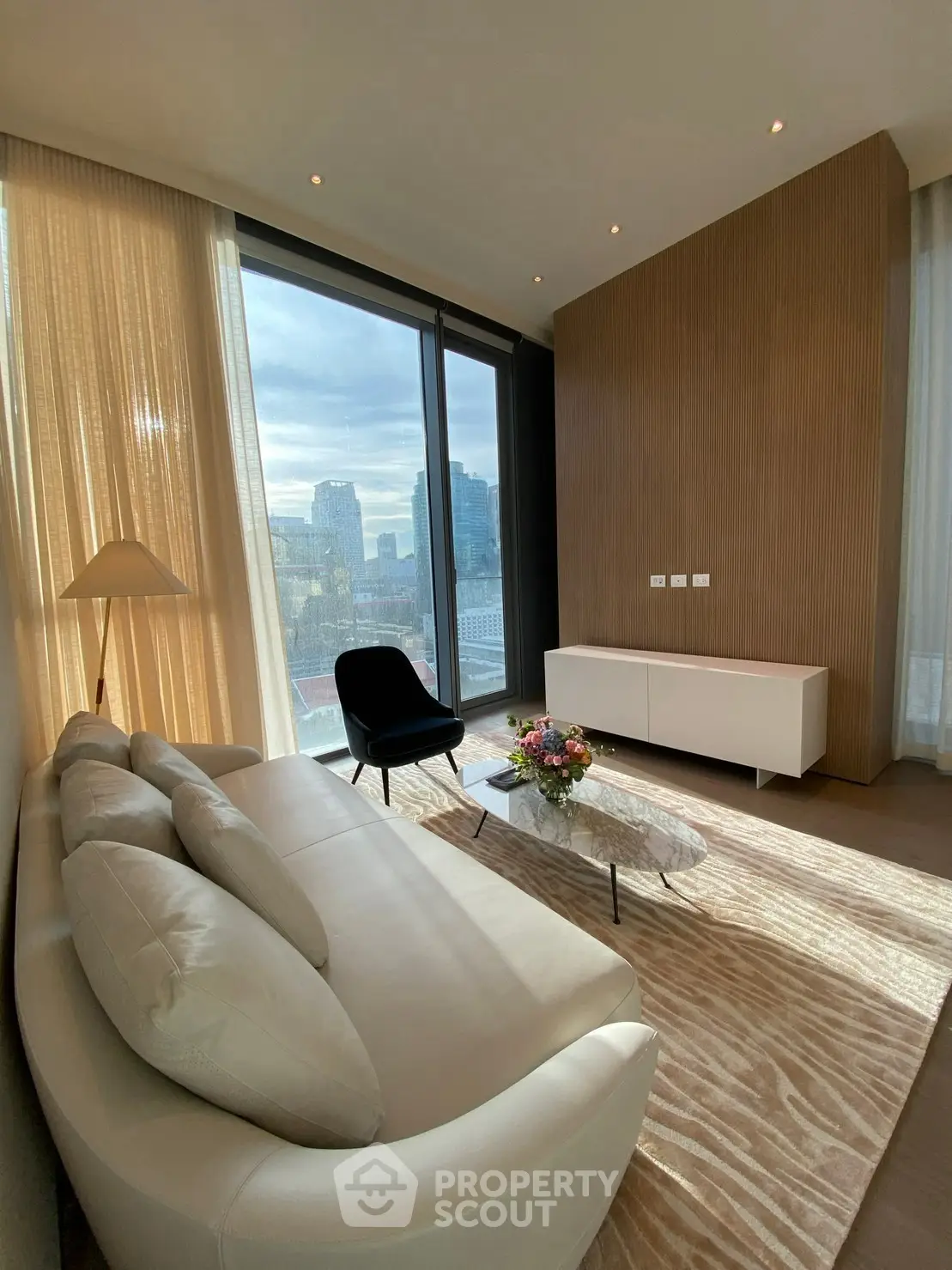 Luxurious living room with stunning city view, elegant decor, and natural light.