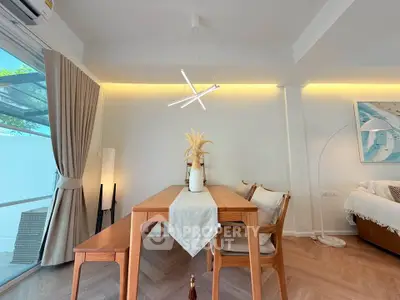 Modern dining area with wooden table, stylish lighting, and cozy decor