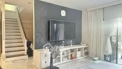 Modern living room with stylish TV wall and elegant staircase