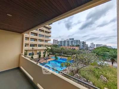 Spacious balcony with stunning pool view in modern apartment complex
