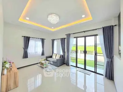 Spacious living room with modern decor and large windows offering scenic views.