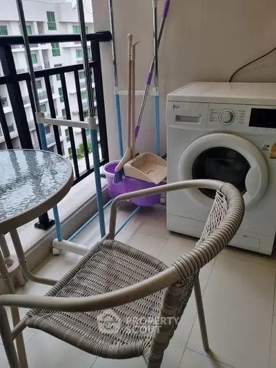 Cozy balcony with washing machine and seating area in modern apartment.