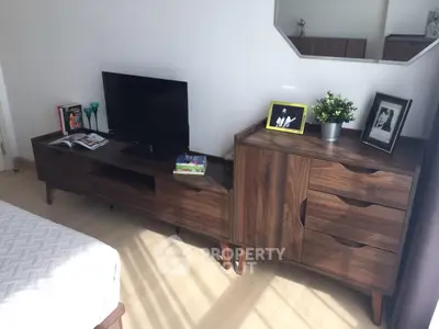 Modern bedroom with stylish wooden furniture and TV setup