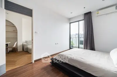Modern bedroom with city view and adjacent study area, featuring sleek wooden flooring and minimalist design.