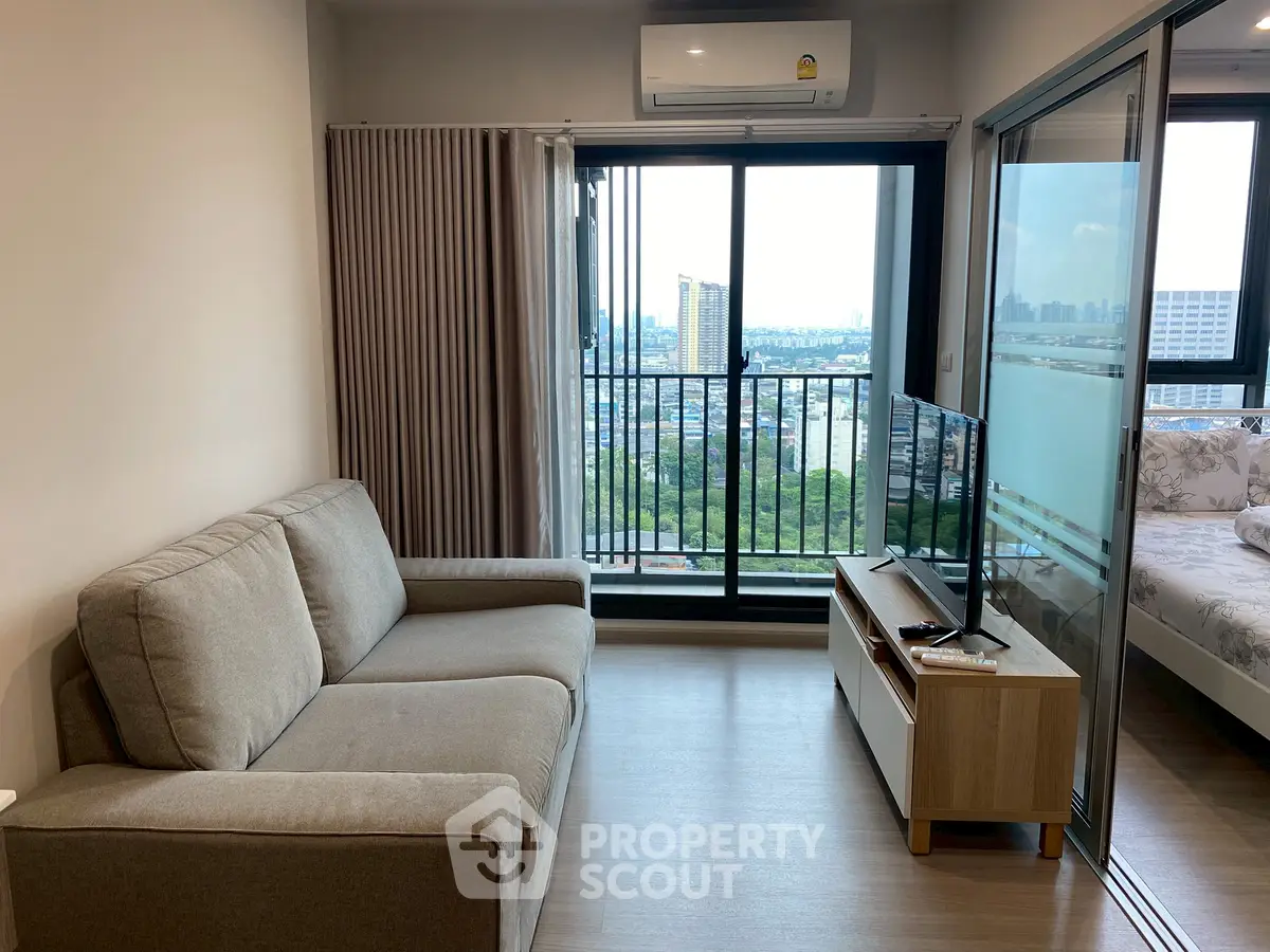 Modern living room with city view, cozy sofa, and sleek TV setup.