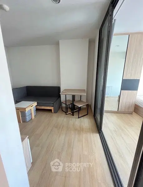 Modern living room with sleek furniture and wooden flooring in a cozy apartment.