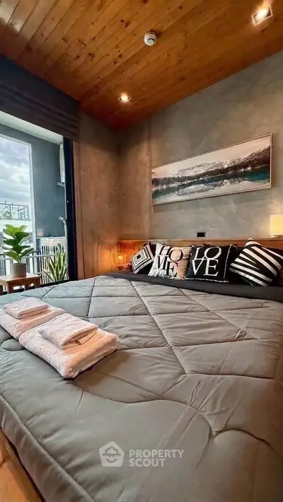 Luxurious bedroom with modern decor and balcony view, featuring cozy bedding and stylish artwork.