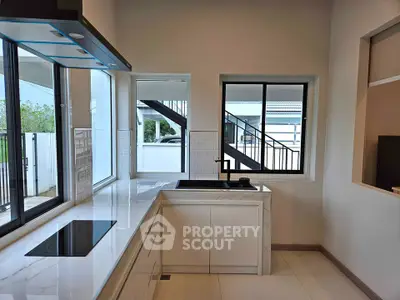 Modern kitchen with sleek countertops and large windows in a contemporary home