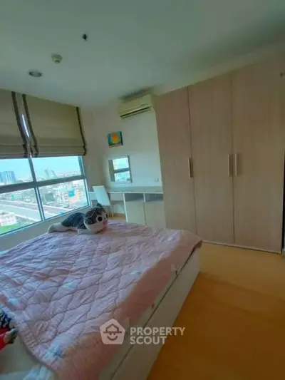 Cozy bedroom with city view, featuring a large wardrobe and stylish decor.