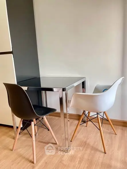 Modern dining area with sleek black and white chairs and a minimalist table, perfect for compact spaces.