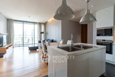 Modern open-plan living room with kitchen island and city view balcony.