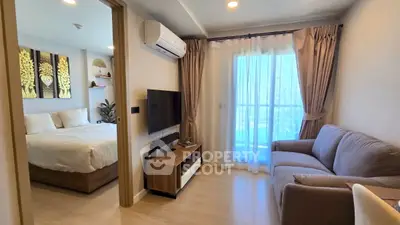 Modern living room with cozy sofa and TV, adjacent to a stylish bedroom