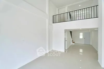 Spacious modern interior with high ceilings and mezzanine level, perfect for contemporary living.