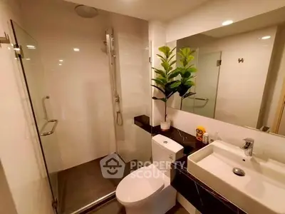 Modern bathroom with glass shower, sleek fixtures, and elegant decor