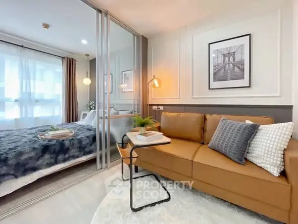 Modern living room with cozy sofa and stylish decor adjacent to a bedroom with sliding glass doors.