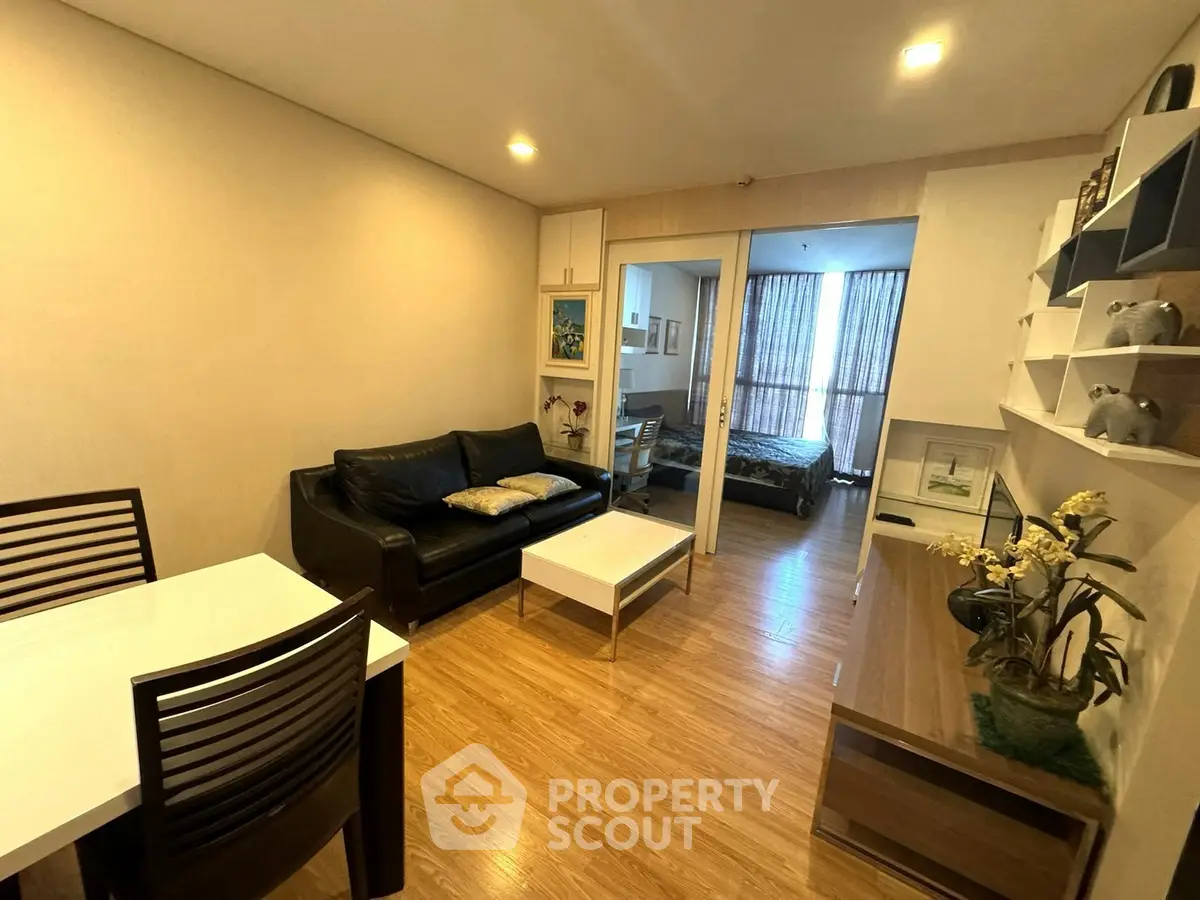 Cozy living room with modern decor and open view to bedroom