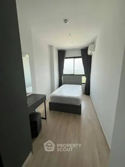 Modern minimalist bedroom with large window and sleek furnishings