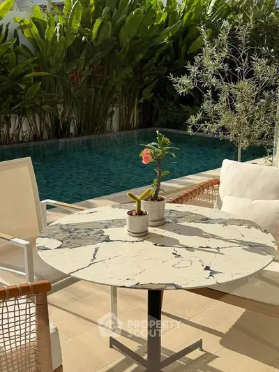 Luxurious poolside patio with elegant marble table and lush greenery