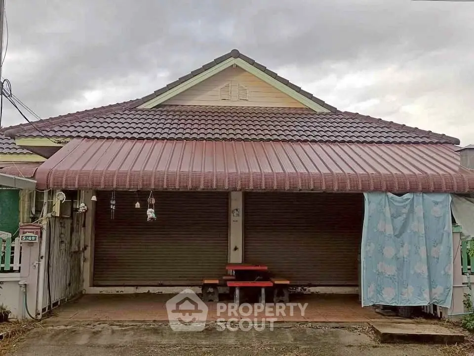 Charming single-story house with tiled roof and cozy front porch, perfect for family living.