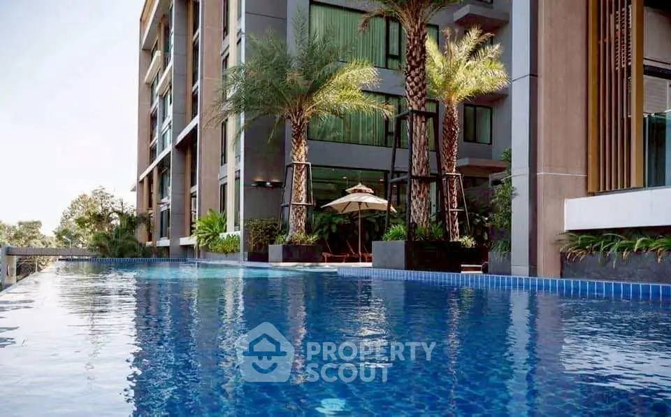 Luxurious modern apartment with stunning poolside view and lush palm trees.