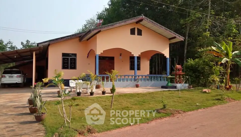 Charming single-story house with lush garden and carport in serene setting.
