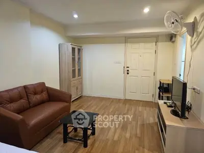Cozy living room with modern furniture and wooden flooring in a stylish apartment.