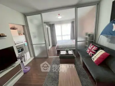 Modern apartment with cozy living room and bedroom separated by sliding glass doors, featuring stylish decor.