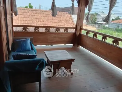 Charming wooden balcony with decorative railings and cozy seating area.