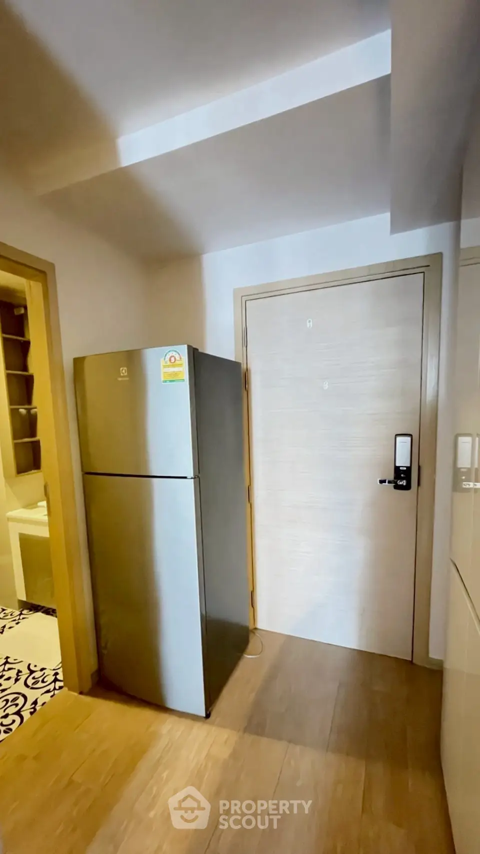 Modern apartment entryway with sleek refrigerator and digital door lock