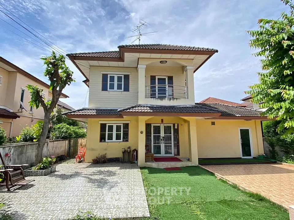 Charming two-story house with a well-maintained garden and paved driveway in a serene neighborhood.