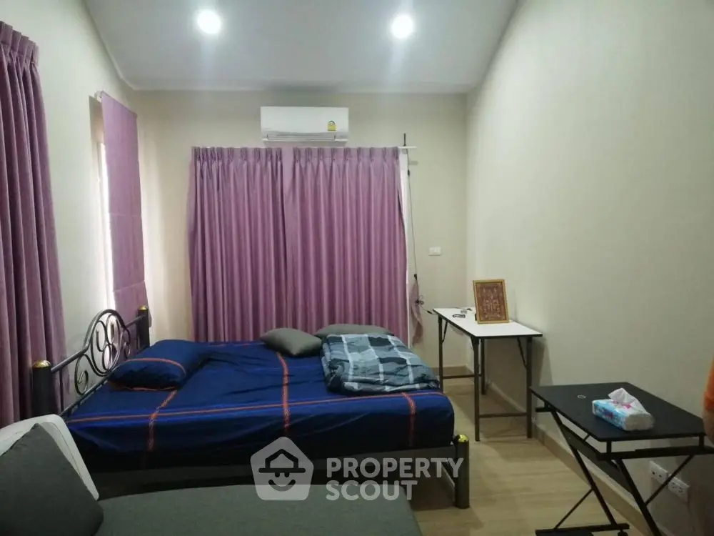 Cozy bedroom with modern furnishings and air conditioning, perfect for comfortable living.