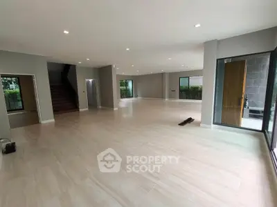 Spacious open-plan living room with modern design and large windows for natural light.